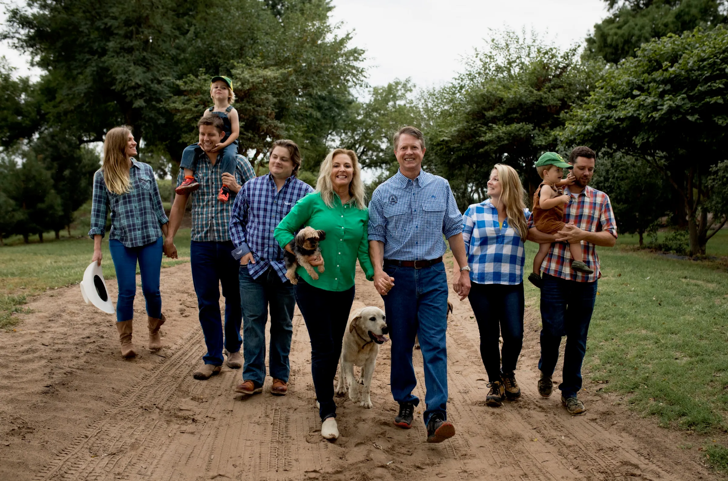The Marshall family walking down a dirt road in Kansas with their dogs.